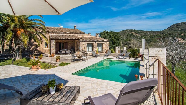 A stone villa with a swimming pool, outdoor seating, and a view of the surrounding hills. - Gorgeous home in Sant Llorenc (Sant Llorenc)