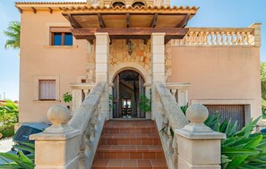 A building with a central staircase flanked by stone balustrades, leading to an arched entrance. - Amazing home in Portocolom with private swimming pool, can be inside or outside (Portocolom)
