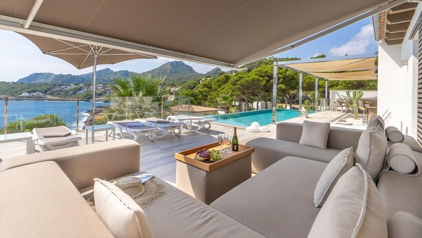 Une terrasse avec des sièges extérieurs, une piscine et une vue sur la montagne.