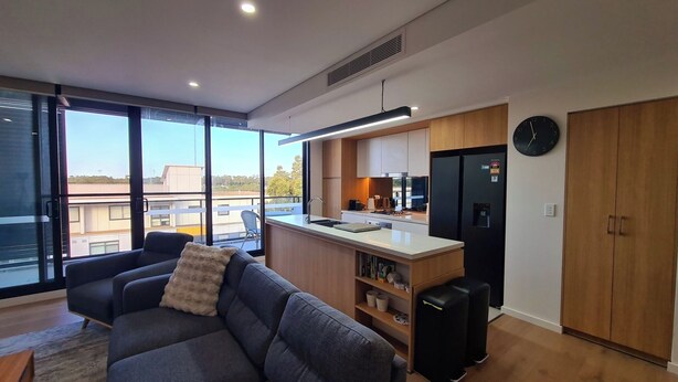 Een modern appartement met woonruimte, een kitchenette en uitzicht over de stad.