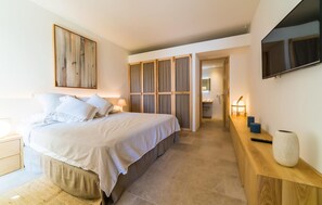 A bedroom with a bed, bedside tables, a TV, and a wooden cabinet. - Awesome apartment in Colonia de Sant Jordi (Colonia de Sant Jordi)