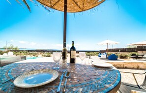 A round table with a mosaic pattern, a bottle of wine, wine glasses, and cutlery. - Awesome apartment in Colonia de Sant Jordi (Colonia de Sant Jordi)
