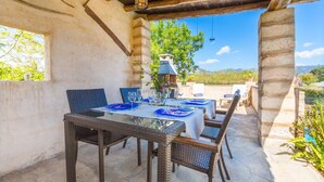 An outdoor dining area with wicker chairs and tables, a brick oven, and a view of the landscape. - Luxurious home in Moscari with private swimming pool, can be inside or outside (Moscari)