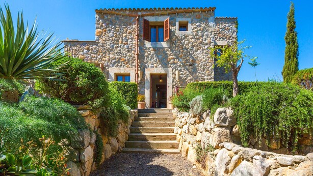A stone building with a central entrance, a staircase leading up to it, and a surrounding garden with various plants and a tall tree. - Luxurious home in Moscari with private swimming pool, can be inside or outside (Moscari)