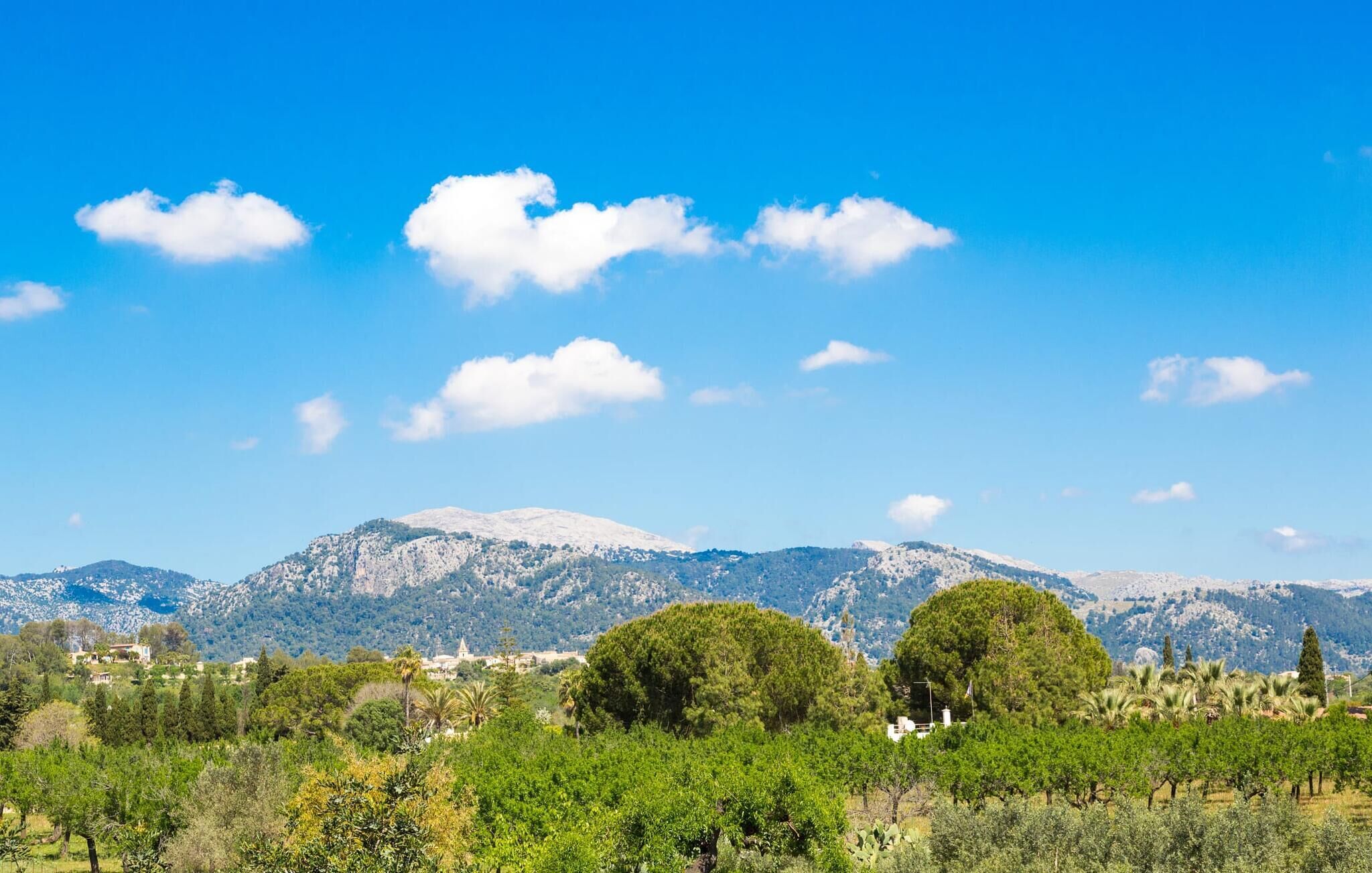 Un paysage montagneux, avec un ciel dégagé et quelques nuages épars.