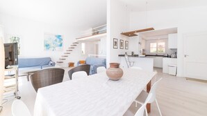 Un intérieur moderne comprenant un coin repas, une cuisine et un espace de vie.