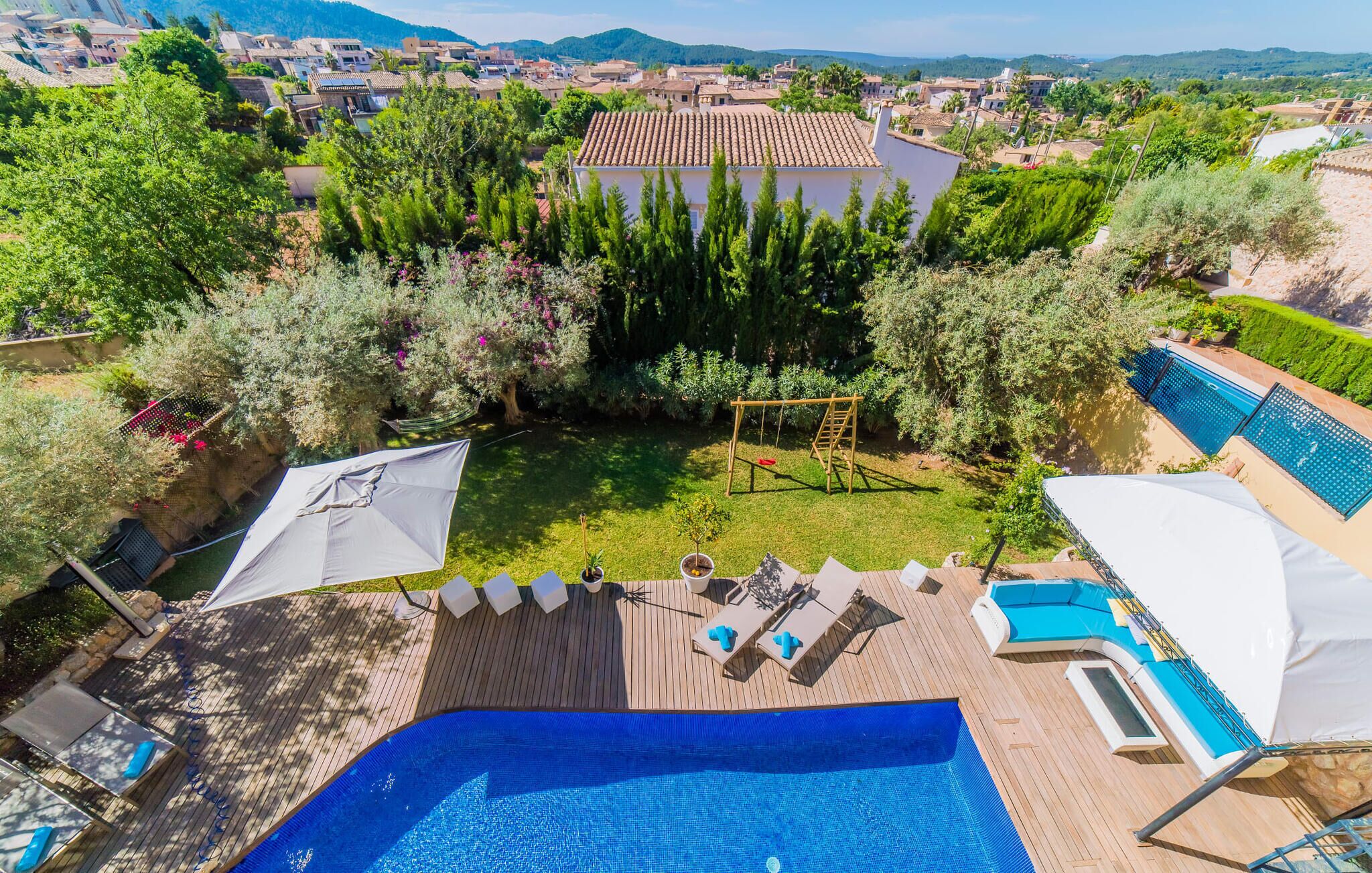 A pool area with a wooden deck, lounge chairs, and a swing set.