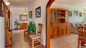 Een gezellige woonkamer met een houten kast, een eettafel met stoelen en een bank.