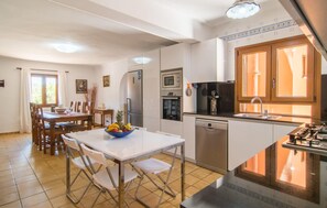 A modern kitchen with a dining area, featuring a refrigerator, oven, microwave, and dishwasher. - Stunning home in Felanitx with private swimming pool, can be inside or outside (Felanitx)