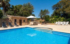 A swimming pool with a stone building, lounge chairs, and potted plants. - Ses Cases de Son Isidros (Manacor)