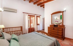 Une chambre à coucher avec un lit, une commode en bois et un miroir.