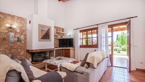 Ein gemütliches Wohnzimmer mit Kamin, Fernseher und einer bequemen Sitzecke.