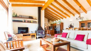 A cozy living room with a fireplace, wooden furniture, and a bookshelf. - Stunning home in Inca with private swimming pool, can be inside or outside (Inca)