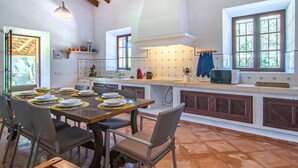 A spacious kitchen with a dining area, featuring a large island, modern appliances, and ample natural light from windows. - Awesome home in Porto Cristo (Porto Cristo)