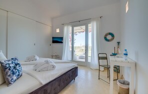 A hotel room with a bed, a desk, a chair, a TV, and a view of the outdoors. - Stunning home in Ses Salines (Ses Salines)