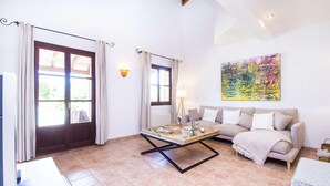 A living room with a sofa, a coffee table, and a painting on the wall. - Ca Na Castell Son Rubi (Selva)