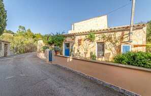 A rustic building with a stone facade, a blue door, and a tiled roof. - Pet friendly home in Galilea (Galilea)