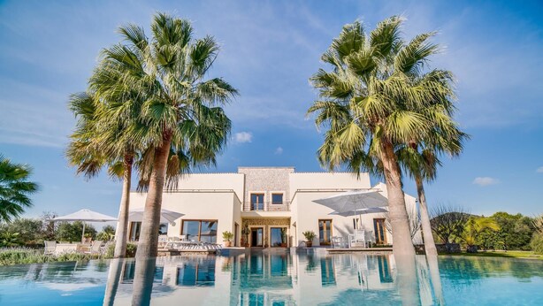 Ein zweistöckiges Gebäude mit einem Pool davor.