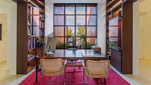 A modern office with a large desk, two wicker chairs, and bookshelves on either side. - Nice home in Manacor with sauna (Manacor)