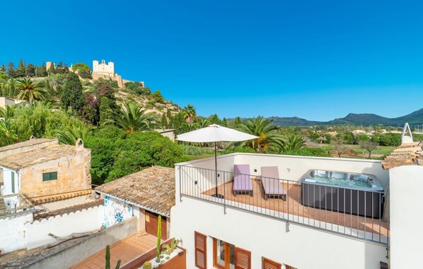 A rooftop terrace with a hot tub, outdoor seating, and a view of a castle on a hill. - Awesome home in Arta with WiFi (Arta)