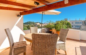 A terrace with wicker furniture, a potted plant, and a view of buildings and hills. - Awesome home in Arta with WiFi (Arta)