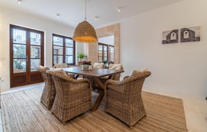 A dining area with wicker chairs, a wooden table, and a hanging light fixture. - Awesome home in Arta with WiFi (Arta)