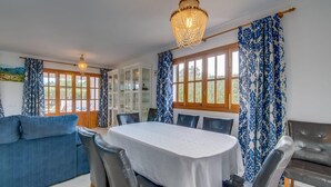 A dining area with a round table, chairs, and a chandelier. - Stunning home in Cala dOr with private swimming pool, can be inside or outside (Cala dOr)