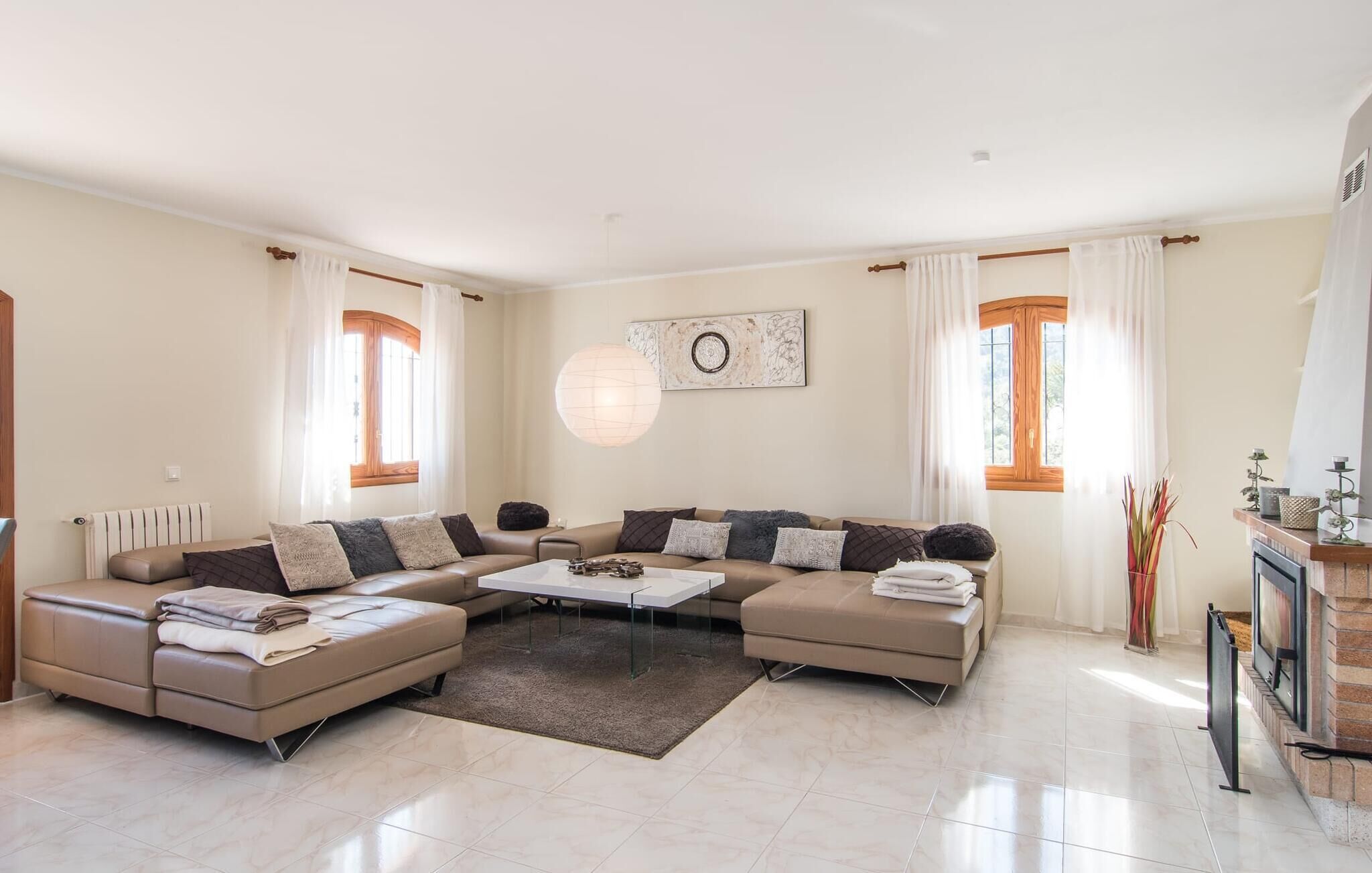 A spacious living room with a sectional sofa, a coffee table, and a fireplace.