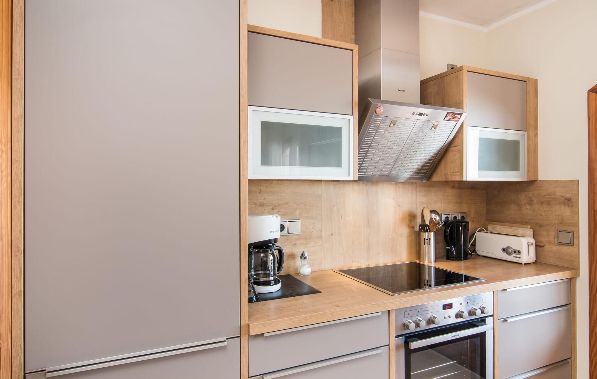 A compact kitchen with a built-in microwave, a coffee maker, and a stove.