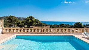 Ein Pool mit Blick auf das Meer und die Hügel.