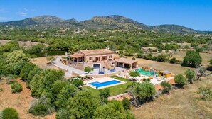 A large house with a swimming pool, surrounded by trees and mountains. - Cozy home in Sant Llorenc with private swimming pool, can be inside or outside (Sant Llorenc)