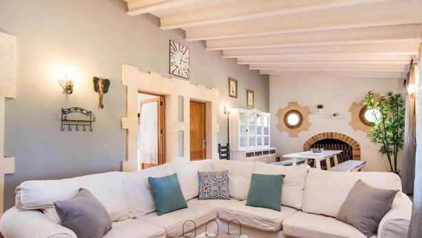 A modern living room with a beige sectional sofa, a white coffee table, and a fireplace.