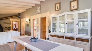 A dining area with a table, chairs, and a cabinet with glass doors.