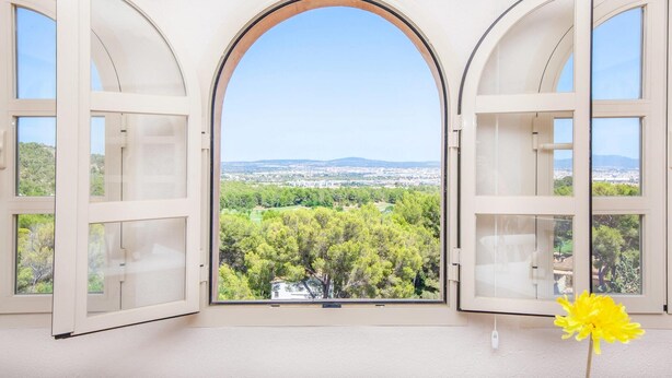 A room with three arched windows overlooking a cityscape and greenery. - La Casa de las Vistas (Palma)