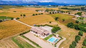 A large house with a swimming pool, surrounded by fields and mountains in the background. - Stunning home in Alcudia with private swimming pool, can be inside or outside (Alcudia)