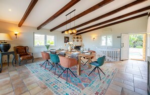 A dining area with a wooden table, chairs, and a patterned rug. - Beautiful home in Colonia de Sant Pere (Colonia de Sant Pere)