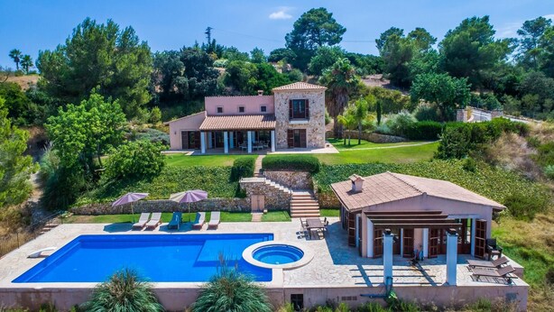 Ein großes Haus mit Swimmingpool, Terrasse und Garten.