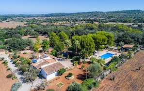 An aerial view of a property with a swimming pool, a white building with a tiled roof, and surrounding greenery. - Cozy home in Llubi with private swimming pool, can be inside or outside (Llubi)
