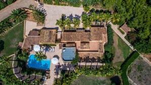 Vista aérea de un resort con piscina, varias zonas de descanso y abundante vegetación.