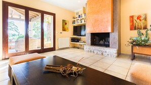 Ein Wohnzimmer mit Kamin, Fernseher und Essbereich mit Tisch und Stühlen.