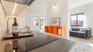A modern kitchen with a built-in induction cooktop, a wine bottle, and a wine glass on the counter. - Amazing home in Algaida with private swimming pool, can be inside or outside (Algaida)