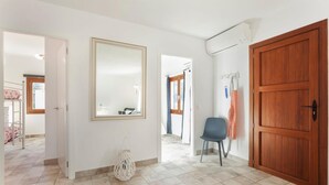 A hallway with a large mirror, a wooden door, and a chair. - Amazing home in Algaida with private swimming pool, can be inside or outside (Algaida)