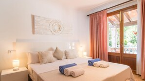 Une chambre d’hôtel avec un lit, une table de chevet, une lampe et une vue sur l’extérieur.