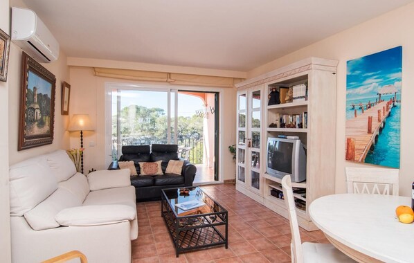 A living room with a sofa, a coffee table, a TV, and a bookshelf.