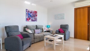 A modern living room with grey sofas, a white coffee table, and a wooden door. - 4 bedroom amazing home in Buger (Buger)