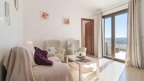 A modern living room with a sofa, two armchairs, a coffee table, and a view of the sea through a sliding glass door. - 4 bedroom amazing home in Buger (Buger)