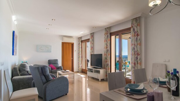 A modern living room with a sofa, TV, and dining area. - 4 bedroom amazing home in Buger (Buger)