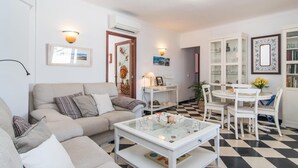 Una sala de estar con sofá, mesa de centro y comedor con sillas y mesa.