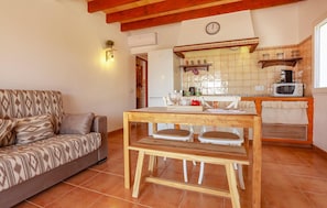 A cozy living room with a sofa and a wooden dining table. - Amazing home in Porreres with private swimming pool, can be inside or outside (Porreres)