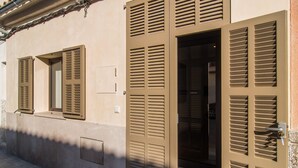 A building facade with multiple shuttered windows and doors, suggesting a secure property. - 2 bedroom luxurious apartment in SIllot Cala Morlanda (SIllot Cala Morlanda)